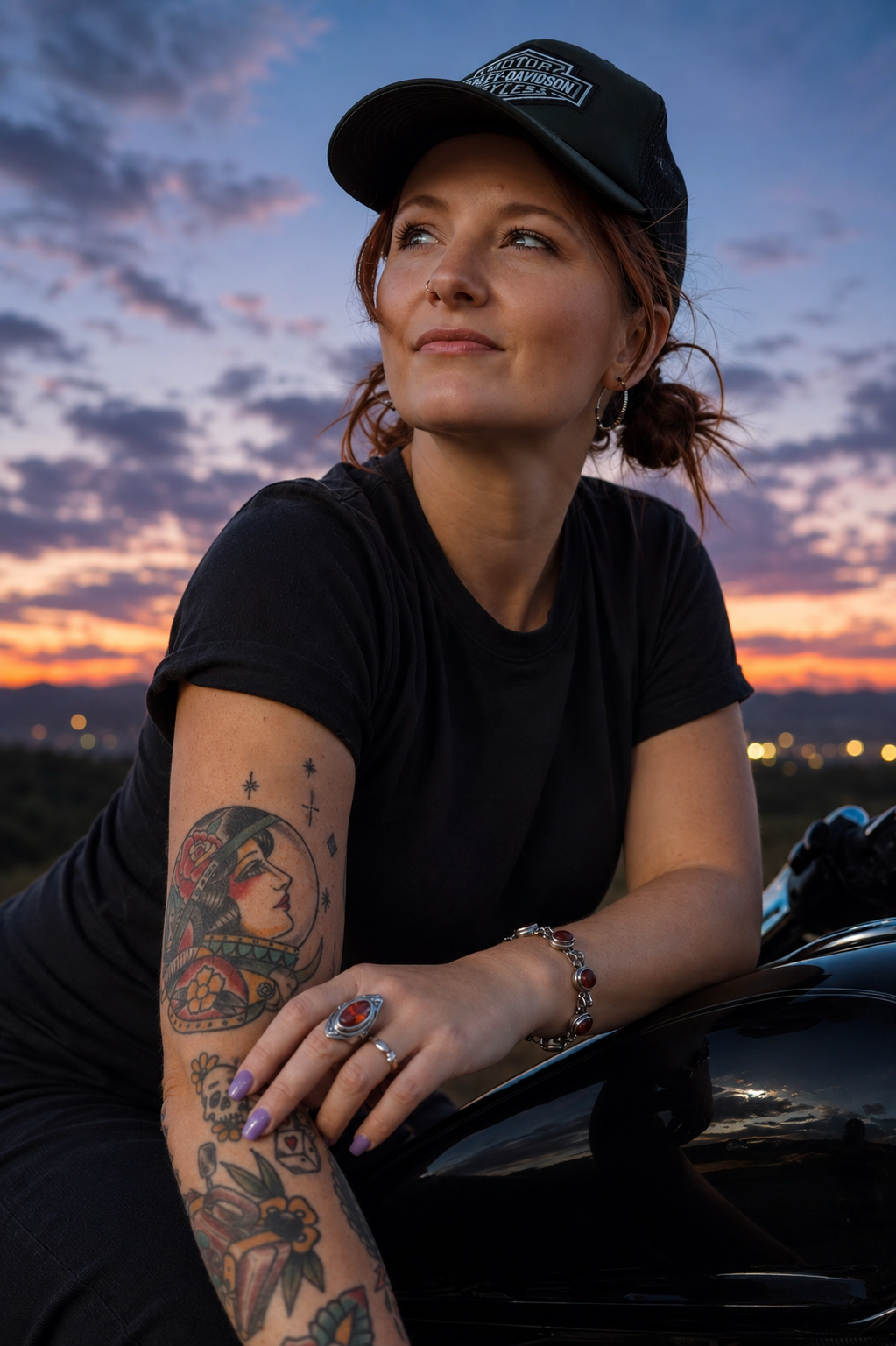 Chelsea Brady at dusk, leaning on a motorcycle under a deep blue sky